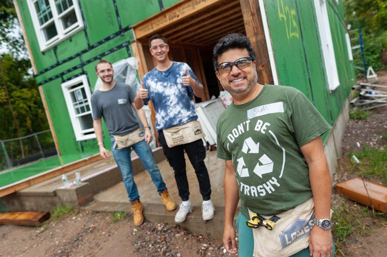 Love, Corbin team at the Habitat for Humanity build 2022: featuring 3 people in front of house