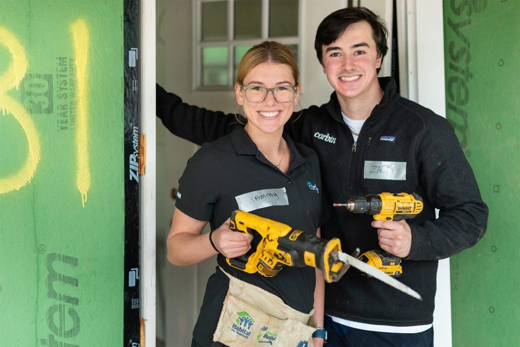Love, Corbin team at the Habitat for Humanity build 2022: featuring 2 people posing with drill and saw