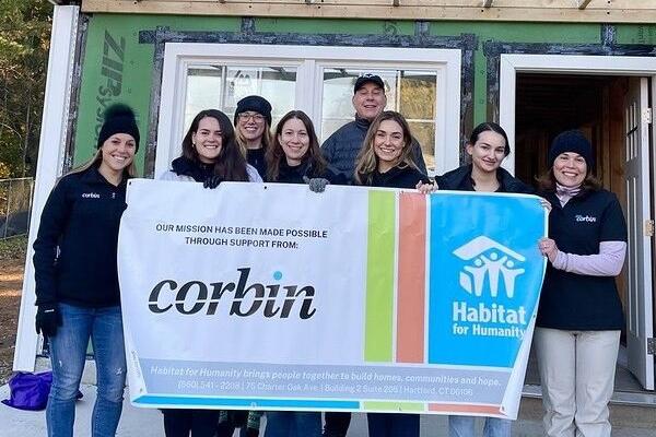 Love, Corbin event: Group shot outside a Habitat for Humanity build